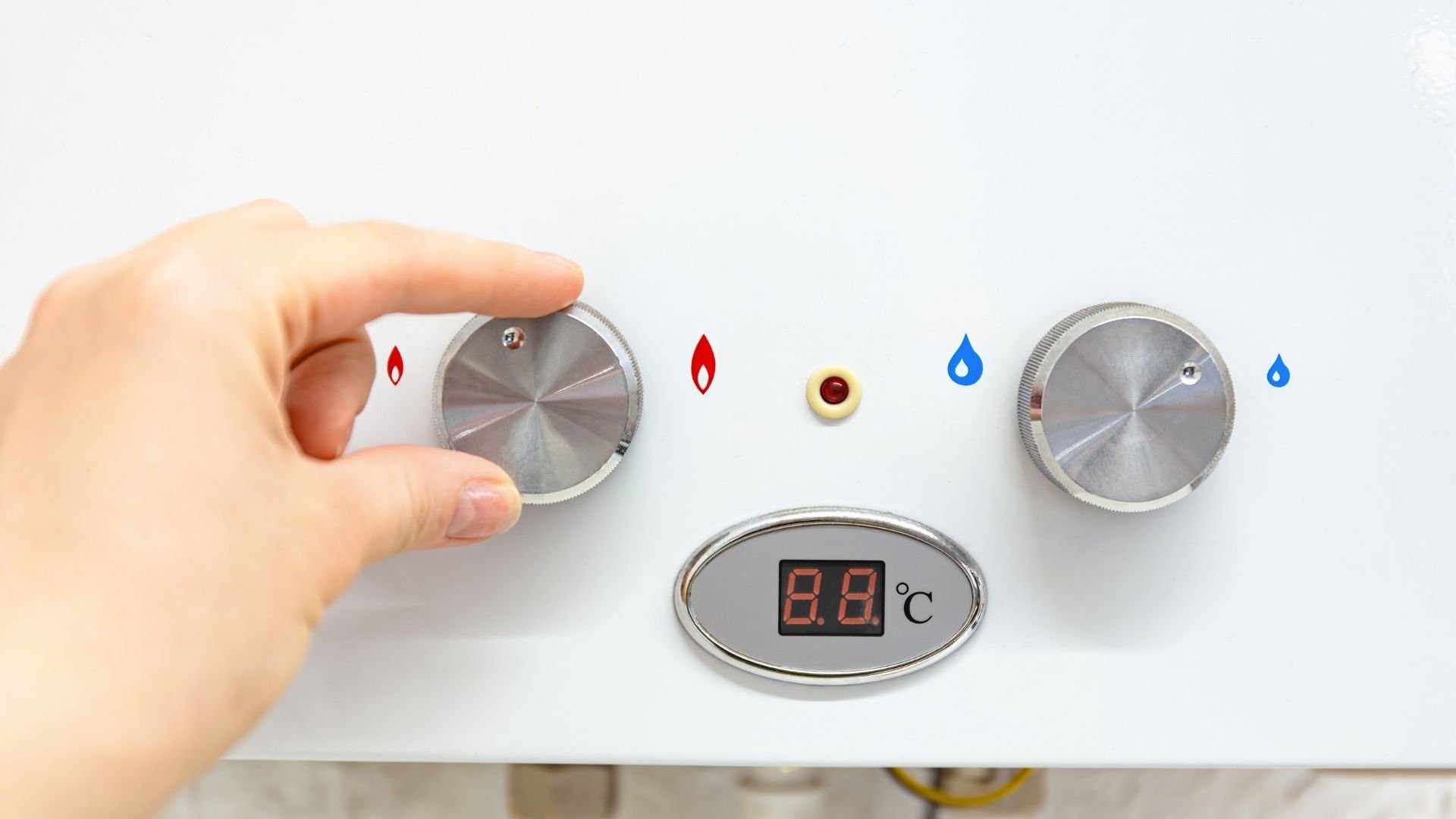 Hand adjusting boiler temperature control with gas and water icons displayed